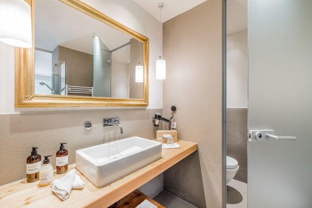 Modernes Badezimmer mit Holz und eleganter Beleuchtung.