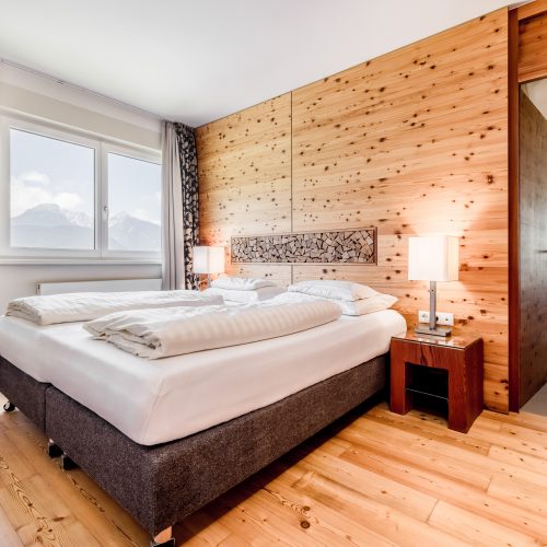 Gemütliches Hotelzimmer mit Holzdekor und Bergblick
