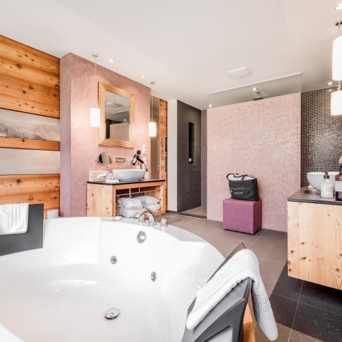 Modernes Badezimmer mit Whirlpool und Holzvertäfelung.