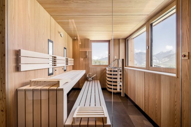 Moderne Sauna mit Holzinterieur und Bergblick.